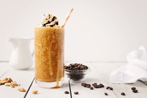 A glass of iced coffee topped with graham cracker grind
