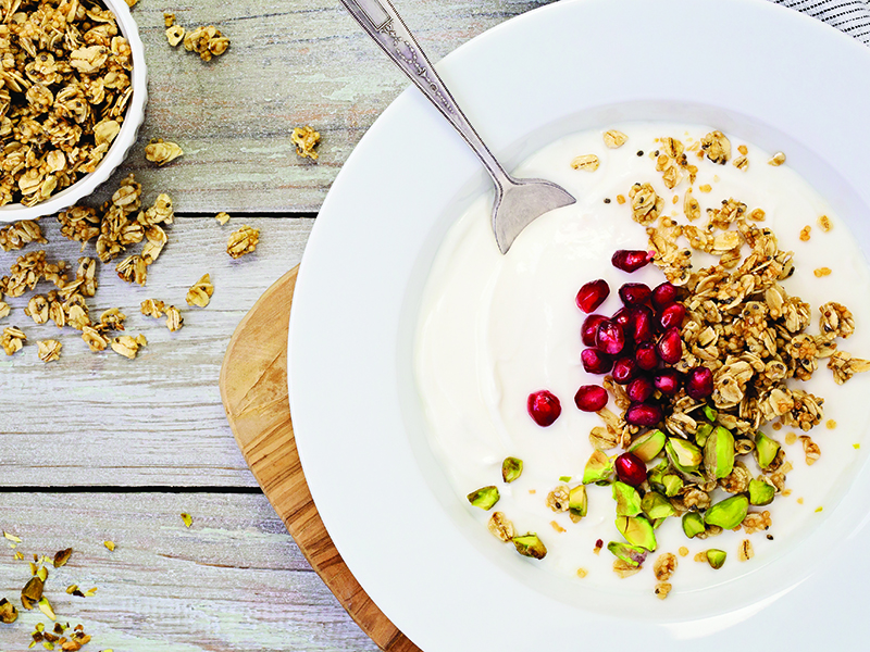 bowl of Greek yogurt, granola, pistachios, and pomegranate